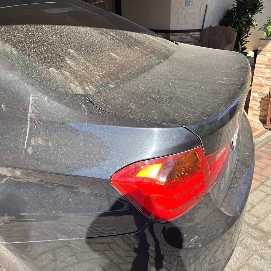 Panel trasero del BMW 320i cubierto de polvo y agua seca