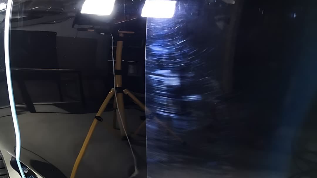 Panel de un auto negro bajo una barra LED: una mitad refleja limpio, la otra muestra swirls